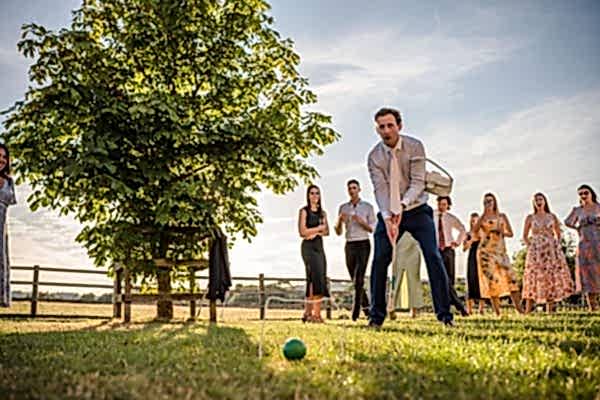 A group of people playing a game of croquet at Dodford Manor Wedding Photographer