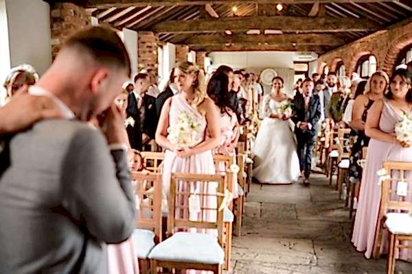A bride and groom walking down the aisle at a Dodford Manor wedding, captured beautifully by a skilled photographer.