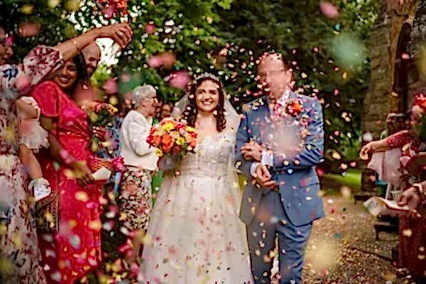Dodford Manor Wedding Photographer captures a bride and groom surrounded by confetti at their wedding.