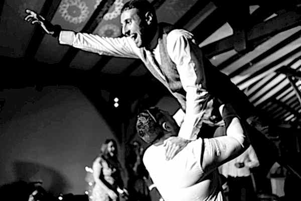 A man is being carried by another man on the dance floor at Dodford Manor Wedding.