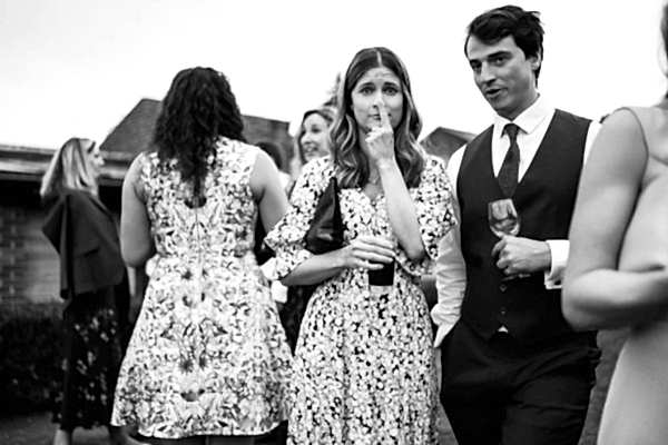 A black and white photo capturing the joyful ambiance of a Dodford Manor wedding party.
