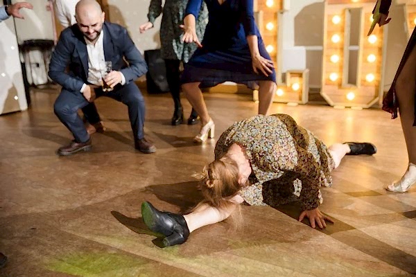 A Dodford Manor Wedding Photographer capturing a woman laying on the floor at a party.