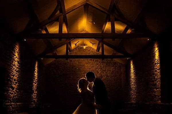 Couple kissing in stone barn