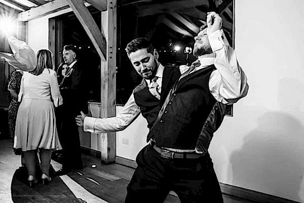 Dodford Manor Wedding Photographer capturing two men dancing at a wedding reception.