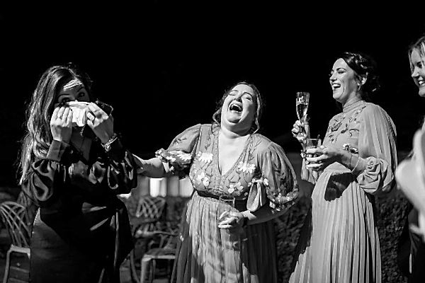 A black and white photo of bridesmaids laughing, captured by a Dodford Manor Wedding Photographer.