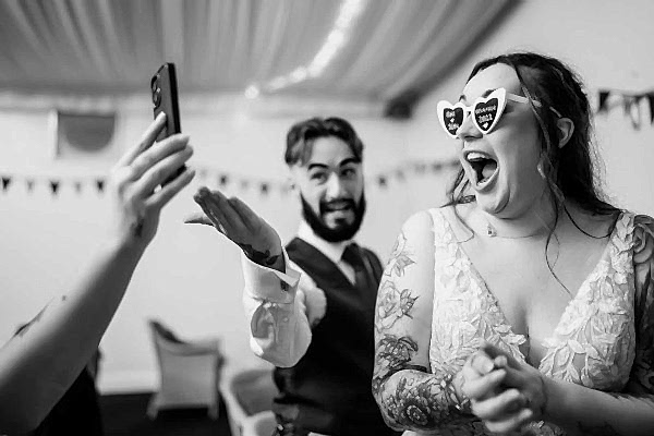 Dodford Manor Wedding Photographer: Capturing the joyful moment of a bride and groom as they take a delightful selfie during their wedding day.