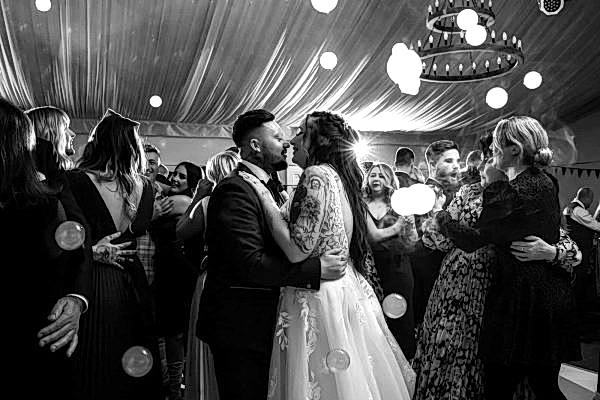 Dodford Manor Wedding Photographer captures a romantic moment as the bride and groom share a heartfelt kiss on the dance floor.