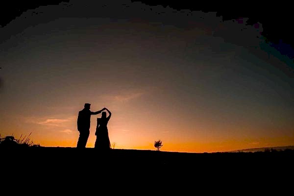 A stunning silhouette of a bride and groom at sunset, captured by a talented Dodford Manor wedding photographer.