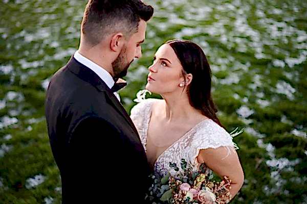 Dodford Manor Wedding Photographer captures a beautiful bride and groom standing in a field of flowers.
