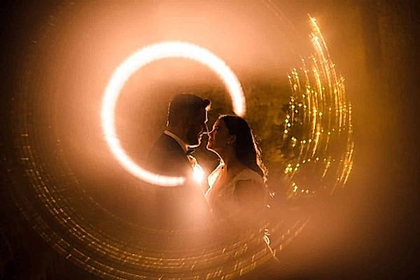 A bride and groom captured in a circle of light by Dodford Manor Wedding Photographer.