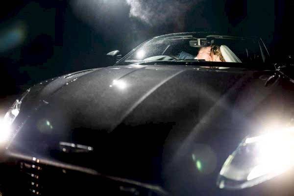 A bride and groom sharing a romantic kiss in a sports car at night, captured beautifully by the Dodford Manor Wedding Photographer.