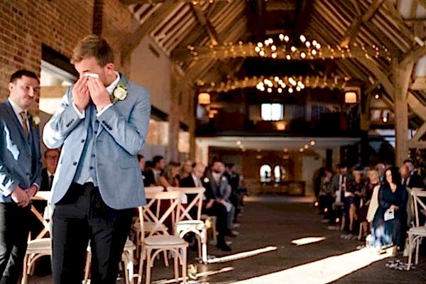 At Dodford Manor, a groom is crying tears of joy during his wedding ceremony.