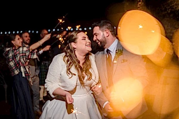 A bride and groom capture magical moments holding sparklers at their Dodford Manor wedding reception with the assistance of a skilled wedding photographer.