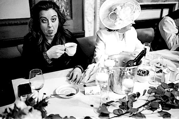 A Dodford Manor Wedding Photographer captures a woman at a table with a cup of coffee.