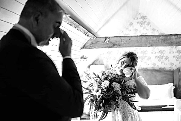 Dodford Manor Wedding Photographer takes a mesmerizing black and white photo capturing the intimate moment of a bride admiring her bouquet.