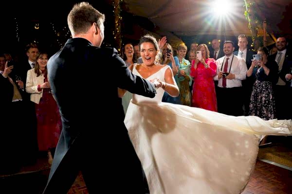 A bride and groom gracefully dancing at their Dodford Manor wedding reception, beautifully captured by a skilled Dodford Manor Wedding Photographer.