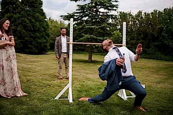 A man in a suit is playing a game with a Dodford Manor Wedding Photographer.