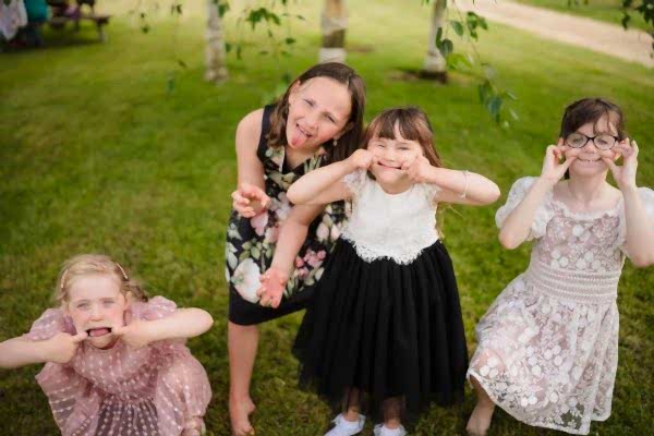 Three little girls posing for a photo captured by a Dodford Manor Wedding Photographer.