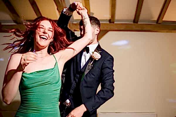 A Dodford Manor wedding photographer captures the magical moments of a man and woman dancing at a wedding reception.