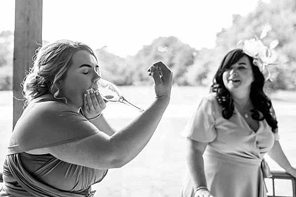 As a Dodford Manor Wedding Photographer, I had the pleasure of capturing two bridesmaids indulging in a glass of wine during the celebration.