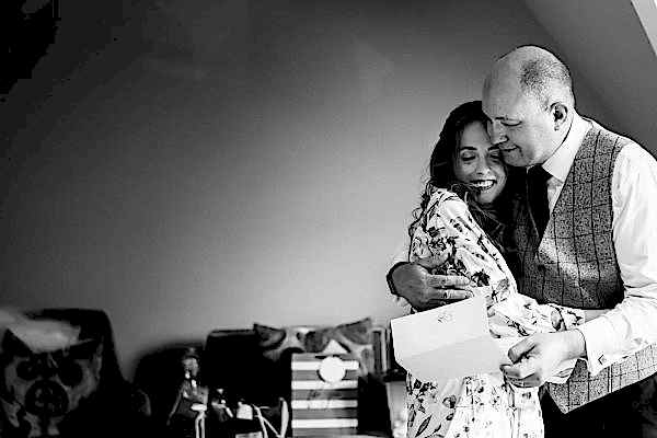 A black and white photo capturing the heartfelt embrace of a man and woman, taken by Dodford Manor Wedding Photographer.
