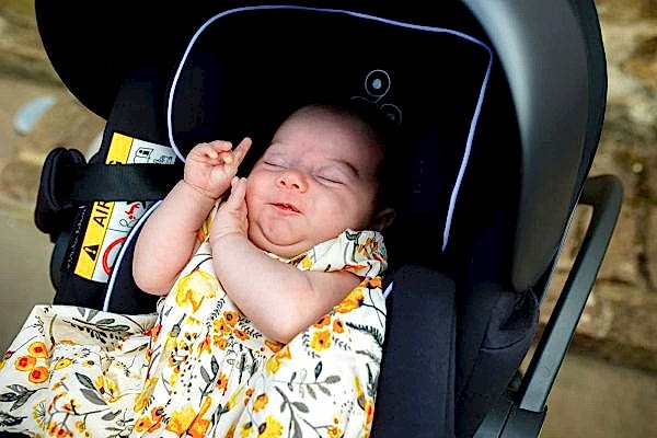 A baby peacefully sleeping in a car seat at Dodford Manor.