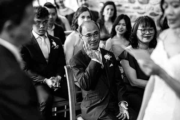 Stunning black and white image capturing a man at a Dodford Manor wedding ceremony.