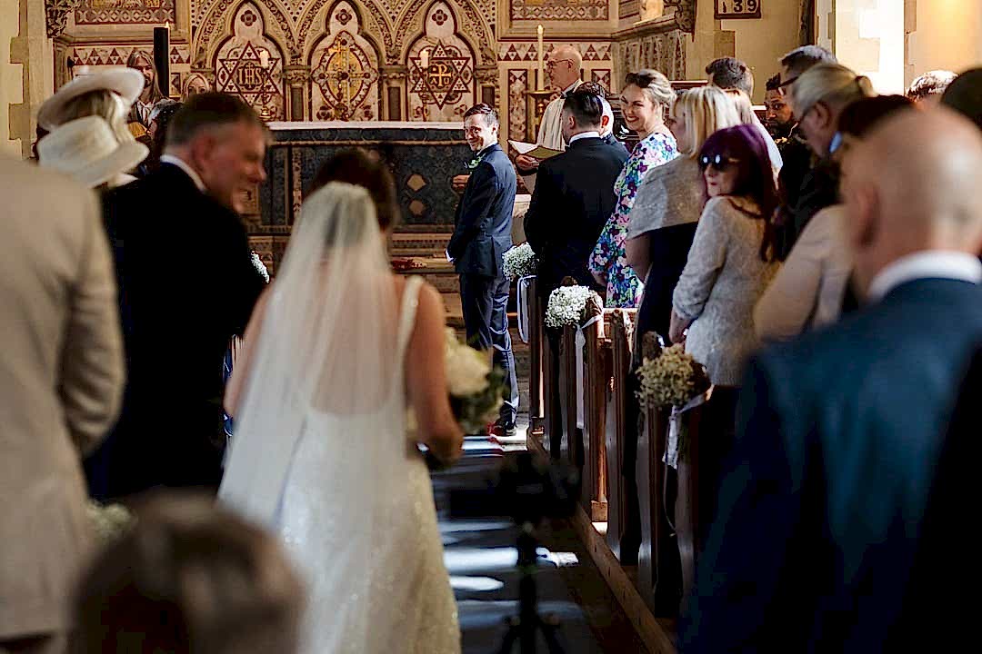 Bride walking down church aisle at wedding ceremony