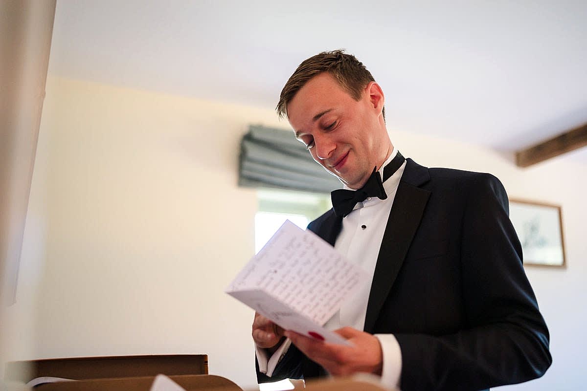 Groom reading a letter pre-wedding.